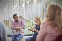 Männlicher Therapeut hört sprechender Frau in Gruppentherapie zu — Stockfoto