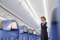 Female flight attendant on empty airplane — Stock Photo