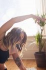 Frau mit Tätowierung praktiziert Yoga Side Body Stretch — Stockfoto