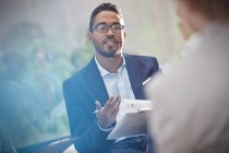 Well dressed black man with clipboard talking in meeting — Stock Photo