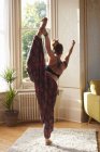 Изящная женщина практикующая йогу король танцовщицы позировать в квартире — стоковое фото