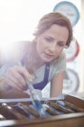 Focused female painter painting furniture with blue paint — Stock Photo