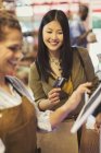 Caixa feminina ajudando cliente sorridente com cartão de crédito na loja de supermercado caixa registradora — Fotografia de Stock
