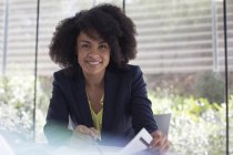 Portrait smiling, confident businesswoman reviewing paperwork — Stock Photo