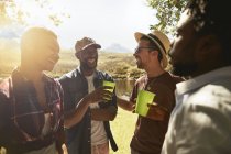 Молоді друзі п'ють і зависають на сонячному літньому узбережжі — стокове фото