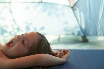 Menina cansada bocejando, descansando dentro da tenda — Fotografia de Stock