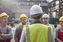 Male foreman talking, meeting with workers in factory — Stock Photo