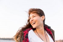 Smiling, enthusiastic woman looking over shoulder — Stock Photo