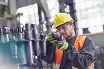 Arbeiter untersucht Stahlteile in Fabrik — Stockfoto