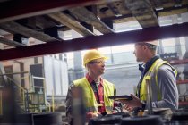 Trabalhadores siderúrgicos com tablet digital falando em siderurgia — Fotografia de Stock