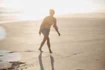 Donna sorridente che cammina sulla spiaggia estiva di sabbia soleggiata — Foto stock