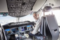 Portrait confident male pilot in airplane cockpit — Stock Photo
