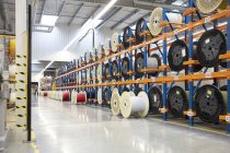 Large spools on racks in fiber optics factory — Stock Photo