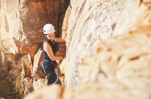 Female rock climber climbing rock — Stock Photo