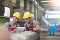 Male workers with clipboard in factory — Stock Photo