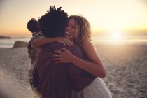 Прихильна пара обіймається сонячним заходом сонця літній пляж — стокове фото