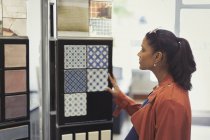 Жінка переглядає зразки плитки в магазині поліпшення будинку — стокове фото