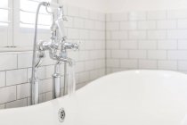 Acqua che scorre dal rubinetto del bagno in vasca da bagno bianca — Foto stock
