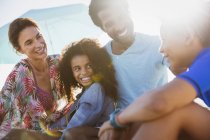 Familia multiétnica hablando juntos en la playa - foto de stock