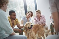 People petting dog in group therapy session — Stock Photo