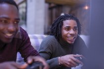 Enthusiastic young men friends playing video game — Stock Photo
