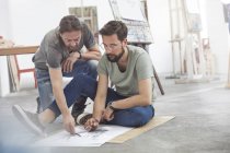 Männliche Künstler skizzieren auf dem Boden im Atelier der Kunstklasse — Stockfoto