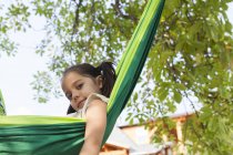 Portrait confident girl in green hammock — Stock Photo