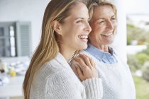 Happy mother and daughter looking away on patio — Stock Photo