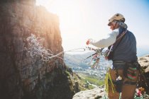 Male rock climber throwing rope — Stock Photo