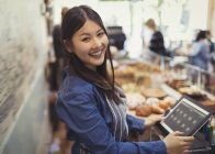 Portrait smiling, confident female cashier at cash register in cafe — Stock Photo