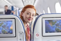 Ritratto giovane donna sorridente con capelli rossi e lentiggini in aereo — Foto stock