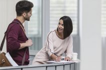 Geschäftsmann und Geschäftsfrau diskutieren Papierkram am Geländer im Büro — Stockfoto