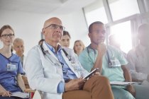Attentive surgeons, doctors and nurses listening in conference — Stock Photo