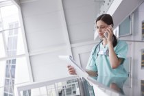 Жіноча медсестра з буфера розмовляє на мобільному телефоні в лікарні — стокове фото