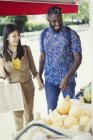 Young couple shopping for produce at market storefront — Stock Photo