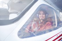 Портрет улыбающейся женщины-пилота самолета в кабине пилота — стоковое фото
