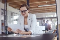 Female design professional reviewing photograph proofs in office — Stock Photo