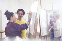 Женщины-художницы рисуют в мольберте в студии художественного класса — стоковое фото