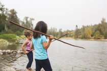 Meninas pesca com paus no lago — Fotografia de Stock
