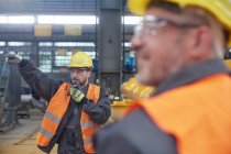 Male foreman using walkie-talkie in factory — Stock Photo