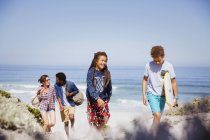 Família caminhando com prancha de boogie na ensolarada praia do oceano de verão — Fotografia de Stock
