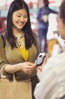Comprador feminino com cartão de crédito usando pagamento touchless na loja — Fotografia de Stock