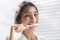 Close up portrait smiling woman brushing teeth — Stock Photo
