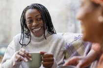 Entusiasta, donna sorridente che ascolta amici e beve caffè — Foto stock
