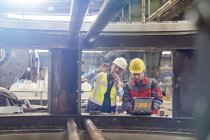Ingenieure mit Laptop untersuchen Teile in Fabrik — Stockfoto