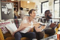 Homens amigos jogando videogame na sala de estar — Fotografia de Stock