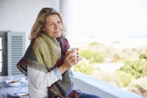 Спокойная женщина пьет кофе на террасе — стоковое фото
