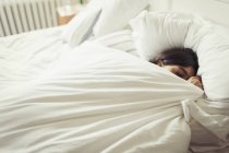Уставшая молодая женщина спит в постели — стоковое фото
