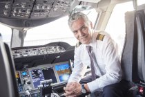 Portrait confident male pilot in airplane cockpit — Stock Photo
