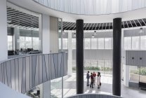 Geschäftsleute im architektonischen, modernen Büro-Atrium — Stockfoto